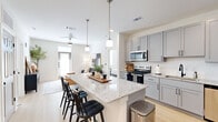 Located at 3755 E McKinney St in Denton, TX, this well-appointed 2-bedroom, 2-bathroom residence offers a thoughtfully designed single-floor layout. The open-concept kitchen and living area serves as the heart of the home, anchored by a granite-topped island with bar seating and pendant lighting overhead. Grey shaker-style cabinetry, a white subway tile backsplash, and a full suite of stainless steel appliances — including a range, microwave, dishwasher, and refrigerator — complete the kitchen. Light hardwood-style flooring flows throughout the main living areas, enhancing the bright, airy atmosphere. The primary bedroom features plush carpet, generous natural light, a ceiling fan, and direct access to a walk-in closet with built-in shelving and dual hanging rods. The en-suite bathroom impresses with floor-to-ceiling marble-look tile, a glass-enclosed walk-in shower with a built-in bench, and matte black fixtures. The second bedroom is equally inviting, with a window overlooking greenery and soft carpeting. The second bathroom features grey cabinetry with granite countertops and light hardwood-style flooring. Two dedicated closets provide ample storage throughout the residence.