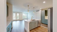 Located at 7051 Stacy Rd in McKinney, TX, this well-appointed 3-bedroom, 3-bathroom residence offers a thoughtfully designed single-floor layout. The kitchen is a standout feature, showcasing sage-green shaker cabinetry, a neutral tile backsplash, quartz countertops, stainless steel appliances, and a central island with a gold-tone faucet accented by pendant lighting overhead. The open living area features warm wood-look flooring, a ceiling fan, and a glazed door leading to a private balcony, with windows that invite natural light and neighborhood views. Each bedroom is carpeted, bright, and well-proportioned, with ceiling fans and multiple windows offering outdoor views. The spacious primary bedroom includes a dedicated walk-in closet with built-in shelving and hanging rods. The bathrooms are elegantly finished with sage-green vanity cabinetry, gold hardware, wood-look flooring, and large mirrors with warm lighting. One bathroom features a soaking tub with floor-to-ceiling tile surround and brushed gold fixtures. Three dedicated closets provide ample storage throughout. The clean, neutral palette and consistent use of quality materials create a cohesive, modern aesthetic across the entire residence.