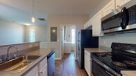 This single-floor residence at 8181 Herald Cv in Blacklick, Ohio offers a thoughtfully designed open-concept layout that seamlessly connects the kitchen and living areas. The kitchen is well-appointed with white cabinetry, granite-style countertops, and a full suite of stainless steel appliances including a refrigerator, range, microwave, and dishwasher. A central island with a breakfast bar provides additional prep space and serves as a natural divider between the kitchen and the adjacent living area. Pendant lighting and hardwood-style flooring add character to the kitchen space.

The spacious living room features plush carpeting, a ceiling fan with light fixture, and multiple windows that invite abundant natural light, creating a bright and welcoming atmosphere. The bedrooms are carpeted and comfortably sized, each equipped with ceiling fans. At least one bedroom includes a walk-in closet with built-in shelving, offering generous storage. The bathroom features a vanity with a single sink, gray countertop, a large mirror, and wood-style flooring. A dedicated laundry area with washer and dryer hookups adds everyday convenience, and the unit includes its own HVAC system for independent climate control.