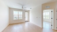 Located at 11805 Pioneers Way in Orlando, Florida, this well-appointed one-bedroom, one-bathroom residence offers a thoughtfully designed single-floor layout filled with natural light and modern finishes. Light wood-tone flooring flows consistently throughout, creating a cohesive and airy feel across every room. The open-concept living and kitchen area forms the heart of the home, featuring a spacious living room with a ceiling fan, large windows, and direct access to an outdoor balcony. The kitchen is outfitted with crisp white shaker-style cabinetry with matte black hardware, white quartz countertops, a subway tile backsplash, a center island with a built-in sink, and a full suite of stainless steel appliances, including a French door refrigerator, range, over-the-range microwave, and dishwasher. Pendant lighting above the island adds a modern touch. The generously sized primary bedroom benefits from multiple large windows that invite abundant natural light and scenic outdoor views, along with a ceiling fan and access to a dedicated walk-in closet. The bathroom offers a dual-sink vanity with white cabinetry, quartz countertops, matte black fixtures, a large mirror, and a glass-enclosed walk-in shower, all finished with consistent light wood flooring for a clean, contemporary aesthetic.