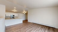 This single-floor, 2-bedroom, 2-bathroom unit offers a practical and comfortable layout with modern finishes throughout. The open-concept kitchen and living area serves as the heart of the home, featuring durable wood-look vinyl plank flooring, a ceiling fan, and baseboard heating. The kitchen is outfitted with white shaker-style cabinetry, granite-style countertops, a peninsula with a built-in sink, and stainless steel appliances including a refrigerator, electric range, and over-the-range microwave. Both bedrooms are carpeted and generously sized, with the primary bedroom offering a ceiling fan and ample room for furnishings. Natural light enters through well-placed windows, including a window in the secondary bedroom that overlooks the surrounding neighborhood. The two bathrooms are finished with white cabinetry, granite-style countertops, and wood-look flooring; one bathroom includes a walk-in shower. A dedicated laundry room with a full-size washer and dryer and built-in wire shelving adds everyday convenience. The overall aesthetic is clean and neutral, with a consistent palette of whites and warm wood tones creating a cohesive, move-in-ready environment.
