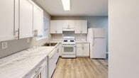 Located at 1700 RT 37 W in Toms River, NJ, this single-story, two-bedroom, one-bathroom home offers a thoughtfully designed layout with clean, modern finishes throughout. Light-toned luxury vinyl plank flooring flows seamlessly across all living areas, creating a cohesive and contemporary feel.

The updated kitchen is a standout feature, showcasing crisp white shaker-style cabinetry, marble-look countertops, a gas range, dishwasher, and a full-size refrigerator. A window above the sink allows natural light to brighten the workspace. The kitchen connects to a dedicated dining area, making it ideal for everyday living and entertaining.

The open living and dining rooms are generously proportioned, with recessed lighting and windows that invite natural light. The neutral gray walls and clean white trim lend a fresh, move-in-ready aesthetic throughout.

Both bedrooms feature soft blue-gray walls and vinyl plank flooring. The spacious primary bedroom is well-appointed with multiple closets, offering excellent storage. The second bedroom also includes a closet and a window with outdoor views.

The bathroom is efficiently arranged with a vanity, medicine cabinet mirror, and a tub-shower combination. A hallway connects the living spaces to the bedrooms, with additional closets providing ample storage. This home presents a clean, functional layout well-suited for comfortable single-floor living.