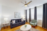 Located in the heart of New Orleans on Common Street, this well-appointed one-bedroom, one-bathroom unit offers a thoughtfully designed open-concept layout that maximizes its efficient footprint. Warm hardwood flooring flows throughout the living and bedroom areas, complemented by clean white walls and ceiling fans that enhance the bright, airy ambiance.

The living and dining area is generously sized, bathed in natural light from multiple large windows dressed with elegant floor-to-ceiling drape panels. The space transitions seamlessly into the kitchen, which features rich wood cabinetry, white quartz countertops, a full suite of stainless steel appliances including a range, microwave, dishwasher, and refrigerator, and a breakfast bar for casual dining.

The spacious bedroom continues the warm hardwood flooring and offers large windows with ample natural light, a ceiling fan, and generous closet storage — with a notable abundance of closet space found throughout the unit.

The bathroom is finished with large-format tiles, a wood-toned vanity with a clean white basin, and well-placed lighting. The overall design aesthetic is modern and cohesive, blending functionality with contemporary style in a prime New Orleans location.