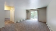 This single-floor residence at 1422 Preston Rdg NW in Walker, Michigan offers a well-organized and functional layout across its living spaces. The living room is a comfortable, open area with plush carpeting, baseboard heating, and a wall-mounted air conditioning unit. A sliding glass door floods the room with natural light and provides direct access to a private balcony overlooking lush greenery, creating a pleasant indoor-outdoor connection. The entryway transitions seamlessly from hardwood-style flooring into the carpeted living area.

The galley-style kitchen is efficiently designed, featuring rich dark cabinetry, light countertops, hardwood-style flooring, a double-basin sink, and a full suite of appliances including a gas range, dishwasher, and refrigerator — providing ample storage and workspace for everyday cooking.

The bedrooms are carpeted and well-lit, each with windows that invite natural light and views of the surrounding landscape. One bedroom includes a dedicated walk-in closet alongside an additional standard closet, offering generous storage. The full bathroom is neatly appointed with a wide vanity, large mirror with overhead lighting, and a tiled shower-tub combination, maintaining a clean and practical aesthetic throughout.