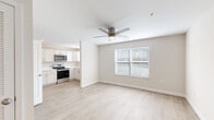 This 1-bedroom, 1-bathroom unit offers a thoughtfully designed single-floor layout that maximizes every square foot. Light wood-style flooring flows consistently throughout the space, contributing to a clean, cohesive aesthetic. The open-concept living area is bright and airy, featuring a ceiling fan, a large window with blinds, and a glass-paned exterior door that brings in natural light and provides outdoor access. The kitchen is efficiently appointed with white shaker-style cabinetry, light countertops, stainless steel appliances including a range, microwave, and dishwasher, and a single-basin sink beneath a window. The bedroom offers a comfortable footprint, complete with a ceiling fan, a window with blinds, and a sliding-door closet with built-in shelving and hanging rods. The bathroom is finished in a clean, neutral palette with a white vanity, light countertop, framed mirror, lighted vanity bar, and wood-style flooring that ties seamlessly into the rest of the unit. Throughout, the space maintains a fresh, move-in-ready appearance with neutral wall tones, crisp white trim, and consistent finishes that create a calm and functional living environment.
