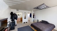 Located along the iconic Historic Route 66 in Flagstaff, Arizona, this efficient one-bedroom, one-bathroom unit is thoughtfully organized across a single floor. The generously sized main room serves as the primary living and sleeping area, featuring neutral carpet flooring, a textured ceiling, a wall-mounted heating unit, and a window that admits natural light. An open coat rack area near the entry provides convenient storage, while an open-rod closet offers accessible wardrobe space directly within the main room.

The kitchen is positioned adjacent to the main area and is equipped with warm-toned wood cabinetry—both upper and lower—light countertops, a single-basin sink, and wood-style flooring, providing a functional and organized cooking space.

The bathroom is accessible from the main room and includes a full tub and shower combination fitted with tile surround and a curtain rod, a toilet, and a vanity with wood cabinetry and overhead lighting—maintaining a clean, practical layout.

Throughout the unit, white walls and consistent flooring materials create a cohesive, straightforward aesthetic. The layout maximizes every square foot, making this a practical and self-contained living space well-suited for single occupancy in the heart of Flagstaff.