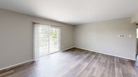 Located at 240 Chez Vant Ct in Hazelwood, MO, this two-bedroom, one-bathroom unit offers a practical and well-organized single-floor layout. The living room is bright and spacious, featuring wood-style laminate flooring and a sliding glass door fitted with vertical blinds that opens to a private balcony with outdoor views of surrounding greenery. The kitchen is efficiently designed with warm wood cabinetry, a full suite of black appliances including a refrigerator, electric range, and dishwasher, along with a sink and ample counter space. The flooring continues the wood-style laminate found in the living area, creating a cohesive feel. Both bedrooms are carpeted in neutral tones and feature soft, neutral wall colors. The primary bedroom is generously sized and includes a closet, while the second bedroom also offers closet storage. Natural light flows into both rooms through windows with blinds. The bathroom is clean and functional, featuring tile walls, a full bathtub with shower, and classic white fixtures. A connecting hallway ties all rooms together efficiently. Throughout the unit, neutral paint tones, white trim, and consistent finishes create a clean, move-in ready environment.