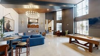 Located at 4181 Davie Dr in Fort Lauderdale, FL, this expansive single-floor community lounge offers a refined and versatile gathering space designed with modern sophistication. The open layout is anchored by dramatically soaring ceilings clad in warm wood paneling, which contrast beautifully against crisp white walls and polished concrete floors throughout.

The space is organized into several distinct functional zones. A wet bar and kitchenette area features dark cabinetry, a stainless steel refrigerator, open shelving, and bar-height seating — ideal for casual entertaining. Nearby, round dining tables with upholstered chairs provide additional seating beneath elegant pendant lighting. A statement chandelier with exposed Edison-style bulbs serves as a focal point over the central lounge area, where plush sectional sofas and curated artwork, including bold Western-themed pieces, create an inviting atmosphere.

A separate seating nook offers a more intimate retreat, complete with a sectional sofa, layered rugs, and lush indoor trees that bring a natural element to the space. The billiards area, framed by floor-to-ceiling windows, allows abundant natural light to pour in while offering glimpses of the outdoor pool area. Structural concrete columns add an industrial edge, complementing the overall contemporary design aesthetic.