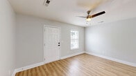 Located at 101 Cypress Plantation Rd in Moncks Corner, SC, this well-designed one-bedroom, one-bathroom home offers a thoughtfully organized single-floor layout. Light wood-style flooring runs throughout, lending a clean, cohesive aesthetic to every room.

The open-concept kitchen and living area forms the heart of the home. The kitchen is a standout feature, equipped with gray shaker-style cabinetry, subway tile backsplash, and a full suite of stainless steel appliances, including a range, microwave, and refrigerator. A large peninsula with striking marble-look quartz countertops provides bar seating for two, making it ideal for casual dining or entertaining. A pendant light and recessed lighting complete the kitchen's polished look.

The living area is bright and airy, featuring a ceiling fan, neutral gray walls, and an abundance of natural light admitted through windows with blinds. The entry area, framed by a classic paneled white door and flanked by windows, adds a welcoming feel.

The spacious primary bedroom comfortably accommodates a full furniture arrangement and includes a ceiling fan, ample closet access, and soft neutral tones that carry throughout. The bathroom features a full tub-shower combo with white tile surround, chrome fixtures, and a clean, functional design. This home delivers a modern, move-in-ready living experience.