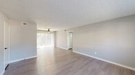 This renovated two-bedroom, two-bathroom unit in Columbia, SC offers a thoughtfully updated interior with a clean, modern aesthetic throughout. The spacious living room is a standout feature, showcasing light-toned laminate flooring, neutral gray walls, a textured ceiling, and a ceiling fan. Sliding glass doors with vertical blinds flood the room with natural light and provide views of the surrounding greenery.

The kitchen is well-equipped with white shaker-style cabinetry, gray countertops, and a suite of black appliances including a refrigerator, range, and dishwasher. A window above the sink brings in additional natural light, completing this functional and attractive space.

The primary bedroom is generously sized, featuring large windows, laminate flooring, and ample closet access. The second bedroom offers plush carpeting, a bright and airy feel, and easy hallway access. Both rooms feature the same neutral palette and textured ceilings consistent throughout the unit.

Each of the two bathrooms is fitted with a tub-shower combo, updated matte black fixtures and hardware, and gray countertop vanities — a cohesive and modern touch. A hallway with closet storage connects the main living areas to the bedrooms, ensuring a practical and organized layout throughout.