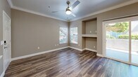 Located at 10270 E Taron Dr in Elk Grove, CA, this single-story residence offers a thoughtfully designed layout that maximizes comfort and functionality. The open-concept living room features warm hardwood-style flooring, crown molding, a ceiling fan, and a sliding glass door that floods the space with natural light while providing access to an outdoor patio area. A built-in niche adds a distinctive architectural touch to the living area.

The kitchen is well-equipped with crisp white shaker cabinetry, quartz countertops, a tile backsplash, and a full suite of stainless steel appliances, including a gas range, refrigerator, dishwasher, and microwave. A peninsula counter provides additional prep space and casual dining potential.

The bedroom is a comfortable retreat, featuring plush carpeting, a ceiling fan, and a window with outdoor views that bring in natural light. The full bathroom is finished with white cabinetry, quartz countertops, a large mirror, and a full tub-shower combination with clean white surround.

A dedicated laundry room includes an in-unit washer and dryer with overhead storage cabinetry, adding everyday convenience. Neutral tones and modern finishes throughout create a cohesive, move-in-ready atmosphere.