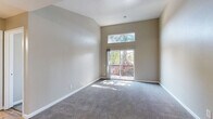 Located at 2005 San Jose Dr in Antioch, CA, this two-bedroom, two-bathroom home offers a thoughtfully laid-out single-floor plan. The living area is a standout, boasting dramatic vaulted ceilings that amplify the sense of openness. A sliding glass door floods the space with natural light and opens onto a private balcony overlooking lush greenery, creating a seamless indoor-outdoor connection. A transom window above the door further enhances the brightness of the room, which is finished with plush wall-to-wall carpeting.

The kitchen is well-appointed with warm honey-toned wood cabinetry, granite-style countertops, and durable wood-look vinyl flooring. Black appliances, including a refrigerator, range, and dishwasher, complement the functional layout with ample upper and lower cabinet storage.

Both bedrooms are carpeted and receive generous natural light through large windows with outdoor views. Two dedicated closets provide practical storage throughout the home. The primary bathroom features a standalone shower, while the second bathroom offers a full tub-shower combination — both include wood-toned vanities with white countertops and wood-look flooring, maintaining a cohesive aesthetic throughout the residence.