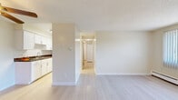 Located at 3131 W Mexico Ave in Denver's Harvey Park neighborhood, this single-floor, 2-bedroom, 1-bathroom unit offers a clean, functional layout with bright, neutral finishes throughout. Light wood-style flooring runs continuously across the living areas and bedrooms, creating a cohesive and airy feel. The living room is a generous, open space featuring a ceiling fan, a textured ceiling, and a large window fitted with vertical blinds that invite abundant natural light and views of the surrounding greenery. Baseboard heating is present throughout, ensuring year-round comfort. The layout flows naturally from the living area toward the kitchen, which is visible in the background with white cabinetry and appliances. Both bedrooms are well-proportioned, each equipped with ceiling fans, large windows with vertical blinds, and sliding mirrored closet doors that enhance the sense of space. The primary bedroom offers a comfortable footprint well-suited for standard bedroom furnishings. The bathroom is a standout feature, showcasing floor-to-ceiling marble-look tile surrounding a white soaking tub, paired with a modern vanity featuring black hardware — a refined touch that elevates the overall space.