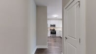 Located at 1824 Defoor Ave NW in Atlanta, GA, this single-story 2-bedroom, 2-bathroom residence offers a thoughtfully designed layout with modern finishes throughout. The open-concept kitchen and living area serves as the heart of the home, where the kitchen stands out with granite countertops, white shaker cabinetry, a classic subway tile backsplash, stainless steel appliances including a gas range and built-in microwave, and a peninsula with seating. Rich hardwood-style flooring flows through the main living areas, complemented by neutral warm-toned walls that create a bright, inviting atmosphere. The living area benefits from natural light streaming through large glass doors with transom windows that frame views of lush greenery. A built-in shelving nook with a lattice detail adds a charming architectural touch. Both bedrooms are carpeted for comfort and served by their own closets with wire shelving systems. Each bathroom features granite-topped white vanities, large mirrors, and wood-style flooring. The primary bedroom is a comfortable retreat with ample square footage. Two hallways provide efficient flow throughout the home, enhancing accessibility between all rooms. This residence combines clean contemporary design with practical, livable spaces in a desirable Atlanta location.