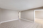 Located at 2070-2080 Hazel Avenue in Beaumont, Texas, this single-story, 2-bedroom, 1-bathroom home offers a practical and well-organized layout across its single floor. The interior is finished with neutral warm-toned walls and crisp white baseboards throughout, creating a clean and cohesive aesthetic.

The living room features light-colored diagonal tile flooring and a textured ceiling, providing a bright, open feel. The combined dining and kitchen area is well-appointed with white cabinetry, granite-look countertops, stainless steel appliances including a range, microwave, and dishwasher, recessed lighting, and matching tile flooring — making it a functional and attractive space for daily living.

Both bedrooms are carpeted and include ceiling fans with lighting, natural window light, and generous closet space. The primary bedroom is notably spacious and features multiple closets, offering excellent storage capacity. A dedicated hallway connects the main living areas to the bedrooms and the full bathroom, which includes a tiled tub/shower combination, a wood-toned vanity with a dark countertop, and tile flooring. A separate laundry room adds everyday convenience. With five total closets distributed throughout the home, storage is a standout feature of this well-designed residence.