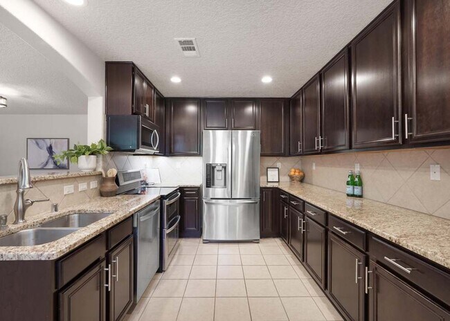 Cocina con encimeras de granito y electrodomésticos de acero inoxidable. - 10824 Arguello Trl NE