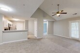 Located at 2400 Whitehall Estates Dr in Charlotte, NC, this 2-bedroom, 3-bathroom single-floor home offers a well-designed layout with a variety of thoughtful architectural details. The open-concept living area is a standout feature, highlighted by soaring vaulted ceilings and a ceiling fan that enhance the sense of airiness and space. Soft carpeting flows throughout the living and bedroom areas, adding warmth and comfort underfoot.

The kitchen is positioned adjacent to the living room, separated by a peninsula counter that provides additional prep space and casual seating. White cabinetry, a subway tile backsplash, stainless steel appliances, and a built-in microwave give the kitchen a clean, functional aesthetic.

The generously sized primary bedroom features a tray ceiling that adds architectural interest, while the second bedroom also offers comfortable proportions with plush carpet and easy access to the hallway. The three bathrooms include a full bath with a soaking tub and tiled shower surround, as well as a secondary bath featuring wood-look flooring, a white vanity, and clean, neutral finishes throughout.

A dedicated laundry room with side-by-side washer and dryer hookups and overhead wire shelving adds practical convenience. Neutral gray tones and white trim are carried consistently throughout, creating a cohesive and inviting interior.