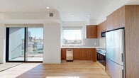 This contemporary apartment, located at 10425–10431 Santa Monica Blvd in Los Angeles, offers a compact yet efficiently designed living space of 660 square feet. The unit features two bedrooms, including a primary bedroom of 120 square feet, and two full bathrooms. The open-concept layout maximizes the use of space, with a modern kitchen as a focal point. The kitchen boasts warm wooden cabinetry, stainless steel appliances, and a clean white backsplash, creating a stylish and functional cooking area.

Throughout the apartment, large windows flood the rooms with natural light and provide stunning city views, enhancing the sense of spaciousness. The hardwood floors add warmth and elegance to the entire space. The bathrooms are designed with a minimalist aesthetic, featuring neutral tones, modern fixtures, and glass-enclosed showers.

The bedrooms, while compact, offer ample space for rest and relaxation, with mirrored closet doors that help to visually expand the rooms. Recessed lighting throughout the apartment contributes to the modern ambiance. This single-floor residence combines contemporary design with practical living, making it an ideal urban dwelling in the heart of Los Angeles.