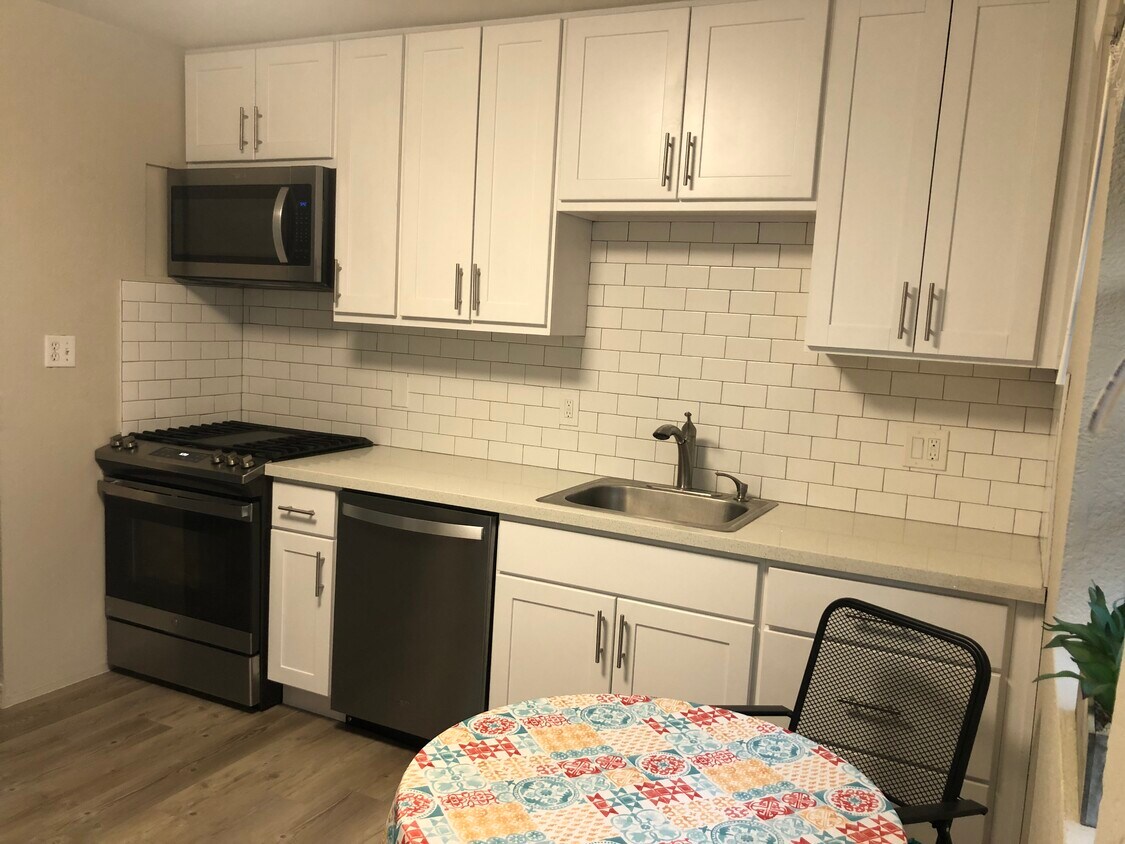 Cocina con electrodomésticos de acero inoxidable, lavaplatos, horno de microondas, azulejos de vidrio - 346 Rose Ave