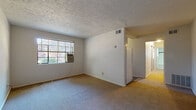 Located at 1750 Clifton Ave. in Columbus, Ohio, this single-floor unit offers a practical and functional layout suited for comfortable everyday living. The main living area features wall-to-wall carpeting, white walls, and a textured ceiling, with a window-mounted air conditioning unit and a window fitted with blinds that allow natural light to filter into the space. HVAC vents are positioned in the ceiling throughout.

The kitchen is compact and well-equipped, featuring a gas range, dark granite-style laminate countertops, a double stainless steel sink, and white cabinetry both above and below the counter, providing ample storage.

The bathroom retains a classic character with black-and-white basket-weave tile flooring, white subway wall tiles accented by a bold black tile border, a soaking tub with an overhead window, and a pedestal sink — a design detail that gives the space a timeless, vintage feel.

The bedrooms are carpeted and bright, each featuring large windows with blinds that invite generous natural light and views of the surrounding greenery. One bedroom benefits from a corner window arrangement, enhancing its airy feel. Closet access is also present in the sleeping areas. Overall, the unit presents a clean, straightforward living environment in a well-established Columbus neighborhood.