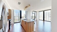 Located on Peachtree Street in Atlanta's vibrant Midtown neighborhood, this modern 2-bedroom, 2-bathroom residence offers a well-designed layout filled with contemporary finishes and sweeping city views. Hardwood flooring flows throughout the space, complemented by crisp white walls and clean-lined architectural details.

The open-concept kitchen and living area serves as the heart of the home, anchored by a sleek island with a waterfall-edge countertop, warm wood cabinetry, stainless steel appliances, and a stylish tile backsplash. Floor-to-ceiling windows bathe the space in natural light while framing dramatic views of the Atlanta skyline.

Both bedrooms are bright and spacious, each benefiting from large windows with city views and hardwood flooring. The primary bedroom includes access to a walk-in closet with built-in shelving and hanging rods. The second bedroom features a ceiling fan and a built-in closet.

The primary bathroom offers a frameless glass walk-in shower, a wide vanity with warm wood cabinetry, and tile flooring. The second bathroom features a soaking tub with a tiled surround, a single vanity, and coordinating tile floors. The residence also includes hallways connecting each area seamlessly, enhancing the overall flow of this thoughtfully designed urban home.