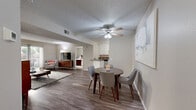 This single-floor, 2-bedroom, 2-bathroom residence in Escondido, California offers a practical and comfortable layout. The kitchen is a standout feature, outfitted with crisp white cabinetry, dark countertops, stainless steel appliances — including a refrigerator, range, and microwave — and a peninsula that adds extra counter space and a natural transition into the living area. Wood-style flooring runs through the kitchen and living areas, lending warmth and cohesion throughout. The living room is bright and inviting, with a sliding glass door that opens to a private balcony, allowing natural light to flow in and providing an outdoor retreat with views of the surrounding greenery. Both bedrooms are carpeted and feature closets with sliding doors. The primary bedroom is generously sized with a window that brings in natural light. The second bedroom also includes a dedicated closet and connects conveniently to the hallway. The two bathrooms are well-appointed with dark countertops, white cabinetry, and wood-style flooring. One bathroom features a sliding glass-door shower enclosure, while the other includes a shower-tub combination with a curtain. Neutral tones throughout the residence create a calm, cohesive ambiance suitable for a variety of personal styles.