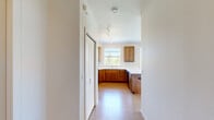 Located in Liberty Lake, WA, this well-appointed one-bedroom, one-bathroom unit offers a thoughtfully designed layout that maximizes its comfortable footprint. The open-concept kitchen is a standout feature, showcasing rich warm-toned wood cabinetry that extends to the ceiling for ample storage, crisp white countertops, a peninsula breakfast bar, and black appliances including a refrigerator, range, and built-in microwave. A window above the sink and an additional window nearby flood the kitchen with natural light and outdoor views of the surrounding greenery. Light wood-style flooring runs throughout the main living areas, lending a clean and cohesive aesthetic. The living area is bright and airy, with multiple windows and a glass-paneled entry door that invites abundant natural light and offers views of the outdoors. Track lighting accentuates the space overhead. The bedroom features plush wall-to-wall carpet and a large window, creating a calm and comfortable retreat. A dedicated closet provides convenient storage. The bathroom includes a walk-in glass-door shower with chrome hardware. The overall ambiance is clean, modern, and move-in ready, with neutral tones creating a welcoming atmosphere throughout.