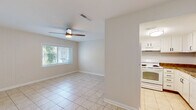 Located at 2711 Allen Rd in Tallahassee, FL, this efficient single-story home offers a thoughtfully organized layout across one bedroom, one bathroom, and several well-utilized spaces. Light-toned ceramic tile flooring runs throughout the entire home, creating a cohesive and easy-to-maintain interior.

The combined living and dining area forms the heart of the home, featuring a ceiling fan with light fixture, a front-facing window that invites natural light and views of lush greenery outside, and direct access to the kitchen. The kitchen is outfitted with white cabinetry featuring dark hardware, granite-style countertops, a subway tile backsplash, and a full suite of white appliances including a range with oven and an overhead ventilation hood.

A long, well-lit hallway connects the main living areas to the private bedroom, which features two double-door closets offering generous storage, and a sliding glass door fitted with vertical blinds that leads to the patio. Additional closet space is accessible from the hallway, totaling four closets throughout the home. The bathroom includes a full tub-shower combination with a curved curtain rod, a white vanity with granite-style countertop, and tile flooring. The patio provides an outdoor retreat, completing this functional and comfortable Tallahassee home.