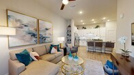 Located in Orlando, FL, this thoughtfully designed 1-bedroom, 2-bathroom residence offers an efficient and stylish single-floor layout. The open-concept living and kitchen area serves as the heart of the home, featuring light wood-style flooring, recessed lighting, and a ceiling fan that enhances the bright, airy atmosphere. Large wall art and neutral tones create a welcoming ambiance in the living space.

The kitchen is outfitted with white shaker-style cabinetry accented by matte black hardware, dark quartz countertops, a white subway tile backsplash with under-cabinet lighting, and a full suite of stainless steel appliances. A peninsula with seating provides a convenient dining option and additional workspace.

The bedroom is a serene retreat, featuring natural light from a window with drapes, ceiling fan, wood-style flooring, and a dedicated closet for storage. Both bathrooms are finished with white vanity cabinetry, dark quartz countertops, large mirrors, and tub/shower combinations with tile surrounds. A hallway connects the private areas of the home seamlessly to the main living spaces, completing this cohesive and functional floor plan.