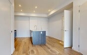 Located at 11805 30 Avenue SW in Edmonton, Alberta, this modern 2-bedroom, 2-bathroom unit offers a thoughtfully designed single-level layout with a clean, contemporary aesthetic throughout. Light-toned hardwood flooring runs continuously across the living areas and bedrooms, complementing the crisp white walls and creating a bright, cohesive feel.

The kitchen is a standout feature, showcasing a two-tone design with white upper cabinetry, dark wood-finish lower cabinets, and a matching island with a light countertop and integrated sink. Stainless steel appliances — including a refrigerator, over-the-range microwave, and electric range — complete the space.

The primary bedroom is a comfortable size and includes access to a dedicated walk-in closet fitted with wire shelving and hanging rods. The ensuite bathroom features elegant marble-look tile flooring and a generous glass-enclosed walk-in shower. The second bedroom is bright and well-proportioned, with a large window offering views of the surrounding neighbourhood. A second full bathroom includes a soaker tub with chrome fixtures and a clean white surround.

The entryway opens into a spacious living area filled with natural light from oversized windows. Recessed lighting and a neutral palette create a calm, modern ambiance throughout this well-appointed Edmonton residence.