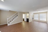 This two-story, 2-bedroom, 3-bathroom home in Houston, TX offers a well-organized layout spread across two floors. The main level features a combined dining and living area with warm wood-look flooring, neutral beige walls, and abundant natural light from large windows with blinds. A standout white brick fireplace anchors the living room, adding character and charm. The kitchen is equipped with dark cabinetry, a subway tile backsplash, a double-basin sink, and black appliances, with direct access to a dedicated laundry room housing a full-size washer and dryer. A pantry adds extra storage convenience on this level. A carpeted staircase with a white banister leads to the upper floor, where both bedrooms are located. Each bedroom features plush carpet, a ceiling fan, and closet access. The generously sized primary bedroom includes natural light from a large window. The bathrooms are finished with dark vanity cabinetry and marble-look countertops. With seven closets throughout, storage is plentiful. A private patio completes the home, offering outdoor space. The neutral color palette and functional layout make this a practical and comfortable residence.