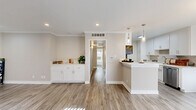 Located in the desirable Studio City neighborhood of Los Angeles, this well-appointed 2-bedroom, 2-bathroom single-story home offers a thoughtfully designed layout with modern finishes throughout. The open-concept living and kitchen area is bright and welcoming, featuring wood-look luxury flooring, recessed lighting, and elegant crown molding that adds a refined touch. A built-in white cabinetry unit in the living area provides both style and functional storage. Large windows with vertical blinds allow ample natural light to fill the space. The kitchen is efficiently designed with crisp white shaker cabinets, a tile backsplash, quartz countertops, and a full suite of stainless steel appliances, including a refrigerator, range, and dishwasher. Both bedrooms are carpeted and generously sized, each benefiting from natural light through wide windows. Three closets, including walk-in options, offer exceptional storage. The primary bathroom features a wide quartz vanity, large mirror, and a glass-enclosed shower. The second bathroom includes a shower-tub combo with a sliding glass door. A hallway connects the private quarters to the main living spaces, ensuring a practical and comfortable flow throughout the home.
