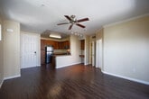 Located at 1551 Summerland Street in Chula Vista, CA, this well-appointed one-bedroom, one-bathroom unit offers a thoughtfully designed single-floor layout. The open-concept living, dining, and kitchen area serves as the heart of the home, featuring rich hardwood-style flooring, crown molding, and a ceiling fan with a sliding glass door that opens to a private balcony with neighborhood views. The kitchen is equipped with warm wood cabinetry, granite countertops, stainless steel appliances including a gas range, microwave, and refrigerator, plus a peninsula that provides additional prep space and a natural divide from the living area. Track lighting adds a functional accent above the kitchen. The bedroom offers plush carpeting, natural light through dual windows, and generous closet storage — the unit includes four closets in total, providing ample organization throughout. The bathroom features tile flooring, a granite-topped vanity with wood cabinetry, and a full soaking tub. Warm neutral tones carry throughout the unit, creating a cohesive and inviting ambiance. A walk-in closet adjacent to the bathroom adds further convenience and storage capacity.