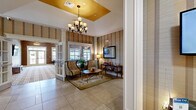 Located at 1000 Meadow Ln in Canonsburg, PA, this generously sized single-floor amenity center spans an expansive footprint across seven distinct spaces, each thoughtfully designed to serve a variety of community needs.

The welcoming lobby sets a refined tone with large-format tile flooring, bold striped wallcovering, and a striking tray ceiling accented in warm gold. An elegant chandelier anchors the space, while decorative columns and a seating area with accent chairs create an inviting first impression. The adjacent lounge continues the sophisticated aesthetic, featuring a fireplace with a crisp white surround, patterned carpet, crown molding, and ample natural light streaming through large windows with views to the outdoors.

The full kitchen is well-appointed with dark espresso cabinetry, granite countertops, stainless steel appliances, and a tile backsplash — ideal for events and gatherings. A separate dining area with multiple seating arrangements and glass door access to the exterior offers a flexible space for group functions.

A dedicated media room provides a large projection screen, surround-sound speaker placement, and plush carpeting for an immersive viewing experience. The fitness center is well-equipped with cardio machines, strength equipment, wall-mounted TVs, mirrored walls, and abundant natural light. A package locker system is also conveniently located within the fitness area.