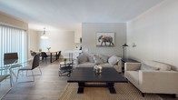 Located at 1101 N Jackson St in Glendale, CA, this single-floor unit offers a thoughtfully updated interior with a cohesive, modern aesthetic. Light wood-look flooring flows throughout, complementing neutral warm-gray walls and clean white trim to create a bright, unified look.

The open-concept living and dining area forms the heart of the space. The living room accommodates comfortable seating and features a peninsula that separates it from the kitchen, while the adjacent dining area is lit by a stylish pendant light and benefits from natural light through a window overlooking greenery.

The galley-style kitchen is well-appointed with white shaker cabinetry, quartz countertops, a deep stainless steel sink with a matte black faucet, and stainless steel appliances including a range, microwave, and refrigerator.

The primary bedroom is generously sized with a wide window, warm lighting, and direct access to an en-suite bathroom featuring a white vanity with quartz countertop, a large mirror, and a glass-enclosed shower. A second bedroom also offers ample natural light through a large window and light wood flooring. A second full bathroom with a shower-tub combination serves the remaining rooms. Built-in closet storage adds practical functionality throughout the unit.