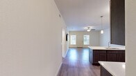 Located at 110 Hampshire #5 in Savoy, IL, this well-appointed two-bedroom, two-bathroom unit offers a thoughtfully designed single-level layout. The open-concept living and kitchen area forms the heart of the home, featuring durable hardwood-style flooring, a ceiling fan, and large windows that bring in generous natural light. The kitchen is equipped with dark espresso cabinetry, stainless steel appliances including a refrigerator, electric range, and built-in microwave, and a peninsula island with pendant lighting and a sink — ideal for both cooking and casual dining.

The two bedrooms provide comfortable retreats, each with plush carpeting and bright neutral walls. The primary bedroom offers a well-sized footprint, while the second bedroom features hardwood-style flooring and a window with an outdoor view. The two bathrooms include one with a soaking tub and tile flooring, and another with a walk-in shower.

A dedicated in-unit laundry room houses a full-size washer and dryer alongside a utility shelf and a window for ventilation. Hallways and a closet add practical storage and circulation throughout the space. Clean white walls, consistent finishes, and a neutral palette give the entire unit a bright, move-in-ready feel.