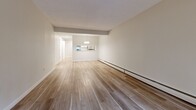 This 860 square foot apartment in North Vancouver offers a harmonious blend of modern design and functional living. The space features three bedrooms, including a primary bedroom of 160 square feet, and one bathroom. The open-concept layout seamlessly integrates the kitchen, living, and dining areas, creating a spacious feel throughout.

The apartment boasts beautiful hardwood flooring throughout, adding warmth and elegance to the space. Large windows in the living area and bedrooms allow for abundant natural light, while a sliding glass door leads to a private balcony, perfect for enjoying outdoor views.

The kitchen is a highlight, featuring sleek white cabinetry, stainless steel appliances, and ample counter space. The bathroom is well-appointed with a modern vanity and fixtures. Closet space is generous, with mirrored sliding doors in the bedrooms providing both storage and visual spaciousness.

The neutral color palette of the walls complements the wood tones, creating a cohesive and inviting atmosphere. The apartment's single-floor layout ensures easy accessibility, while the thoughtful design maximizes the use of the 860 square feet. Located at 1923 Purcell Way in North Vancouver, this apartment offers contemporary urban living in a desirable location.