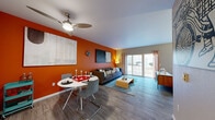 Located at 255 W Broadway in Eugene, Oregon, this thoughtfully designed one-bedroom, one-bathroom unit offers a compact yet well-organized layout across a single floor. The living room immediately captures attention with its bold burnt-orange accent wall, hardwood-style flooring, and a ceiling fan overhead. A large sliding glass door floods the space with natural light and provides direct access to an outdoor patio area. The dining area sits adjacent to the living room, creating an open, cohesive social space. The galley-style kitchen is efficiently arranged with dark countertops, light cabinetry, stainless steel appliances including a refrigerator and electric range, and a built-in dishwasher — all set atop light wood-look flooring. A connecting hallway with a sliding closet door leads to the rest of the unit. The bedroom is a quiet, neutrally toned retreat featuring a window with outdoor views of surrounding greenery, offering ample natural light. The bathroom is finished with soft sage-green walls, light wood-look tile flooring, white cabinetry with dark countertops, a large vanity mirror, and wall-mounted lighting, creating a clean and calming atmosphere throughout.