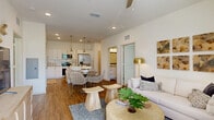 Located at 2950 Landover Blvd in Spring Hill, Florida, this thoughtfully designed 2-bedroom, 2-bathroom residence offers a comfortable and modern living experience across a single floor. The entrance leads into a bright, open-concept living, dining, and kitchen area bathed in natural light, with wood-look flooring flowing throughout the main spaces.

The kitchen is a standout feature, showcasing crisp white cabinetry, a decorative tile backsplash, granite countertops, stainless steel appliances, and a center island with bar seating — all illuminated by stylish pendant lighting. The dining area transitions seamlessly into a welcoming living room with ceiling fan and access to a private balcony.

The spacious primary bedroom features plush carpeting, multiple windows, and a generous walk-in closet outfitted with wire shelving systems. The second bedroom is equally comfortable with its own closet storage. Both bathrooms are finished with granite-topped vanities, white cabinetry, wood-look flooring, and tub-shower combinations with clean tile surrounds. One bathroom also includes built-in open shelving for added storage.

Additional highlights include a dedicated laundry area, four closets throughout, and a warm, coastal-inspired aesthetic that gives the entire residence a bright, inviting ambiance.