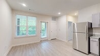 Located at 2050 Wood Duck Ct in Franklin, TN, this two-bedroom, two-bathroom residence offers a clean, modern design across a single floor. The open living area is bathed in natural light through large windows with views of surrounding greenery, and is finished with light wood-style luxury vinyl flooring and recessed lighting throughout. The kitchen is well-appointed with gray shaker-style cabinetry, speckled granite countertops, a stainless steel refrigerator, black gas range, built-in microwave, and dishwasher — all thoughtfully arranged in an efficient L-shaped layout. Both bedrooms feature plush carpeting, natural light from exterior windows, and ceiling fans, providing a comfortable, restful atmosphere. The primary bedroom is a generous size and benefits from convenient access to a dedicated bathroom. The bathrooms are finished with matching gray vanities, granite countertops, and light wood-style flooring. One bathroom includes a full tub/shower combination with clean white tile surround. A walk-in closet provides additional storage. The neutral color palette and consistent finishes throughout lend the space a cohesive, move-in-ready feel ideal for comfortable everyday living in the heart of Franklin, Tennessee.