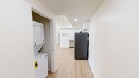 This modern single-floor unit at 14541 Gilmore St in the Van Nuys neighborhood of Los Angeles offers a clean, contemporary living environment with thoughtful finishes throughout. Light-toned hardwood-style flooring runs throughout the space, complementing the crisp white walls and recessed lighting that create a bright, airy atmosphere.

The kitchen is well-appointed with white shaker-style cabinetry extending to the ceiling for generous storage, stainless steel appliances including a gas range, dishwasher, and refrigerator, and ample counter space. A dedicated laundry closet with a stacked washer and dryer unit adds everyday convenience.

The spacious living area is bathed in natural light, with large glass doors opening to a private balcony that offers views of surrounding greenery. The bedrooms are generously sized, each featuring large windows that frame views of mature trees, allowing abundant natural light to fill the rooms.

The bathroom is finished in a clean, minimalist style with white tile, a walk-in shower with a curved curtain rod, and light wood flooring that ties the space together. Throughout the unit, the design emphasizes clean lines, neutral tones, and functional layouts, resulting in a cohesive and modern living environment well-suited to the Southern California lifestyle.