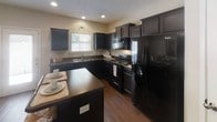 Located at 3946 Keeley Dr in Nashville, TN, this two-story home offers a thoughtfully designed layout with functional living spaces spread across both levels. The kitchen is a standout feature, showcasing rich dark cabinetry, dark countertops, black appliances including a range, microwave, and refrigerator, and warm hardwood flooring. A kitchen island provides additional prep and dining space, making it ideal for everyday meals and entertaining.

The dining area is an intimate nook accented by hardwood floors and wall art, offering a cozy spot for meals. The living room features a ceiling fan, neutral walls, and ample space for comfortable seating arrangements, creating a welcoming and relaxed atmosphere.

The primary bedroom is generously sized, complete with a ceiling fan and soft neutral tones, providing a serene retreat. Additional bedrooms are carpeted and well-lit, each with natural light from windows and closet access, suitable for various living arrangements.

The bathrooms are clean and functional, each featuring a single vanity with a large mirror, white countertops, dark cabinetry, and a tub-shower combination. A staircase connects the two floors, and the overall interior palette of warm beiges and whites lends a cohesive, inviting feel throughout the home.
