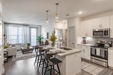 Located at 1000 Everly Way in Gainesville, Georgia, this single-floor residence showcases a thoughtfully designed open-concept layout with modern finishes throughout. The kitchen is a standout feature, outfitted with crisp white shaker cabinetry, granite countertops, a subway tile backsplash, stainless steel appliances, and a central island with pendant lighting — ideal for both cooking and casual dining. Wood-style flooring flows through the main living areas, adding warmth and continuity.

The living area is bright and inviting, with large windows dressed in sheer curtains that welcome an abundance of natural light. The space is well-proportioned, offering a comfortable setting for everyday living.

Each bedroom is carpeted for comfort and features large windows with views to the outside, ceiling fans, and ample closet space. The color-accented walls lend each room a distinct and refined character.

The bathrooms are clean and contemporary, featuring granite-topped vanities, wood-look flooring, glass-enclosed showers, and open shelving for added functionality. Walk-in closets accessible from the bathrooms provide generous storage. Recessed lighting and neutral tones create a cohesive, polished ambiance throughout the entire residence.