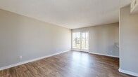 This single-story, 2-bedroom, 1-bathroom unit in Pensacola, Florida offers a straightforward and functional layout finished with clean, neutral tones throughout. The living area features durable wood-style flooring and a textured ceiling, with a glass-panel door providing natural light and direct outdoor views. A sidelight window at the front entry further brightens the entryway, creating a welcoming introduction to the space.

The kitchen is efficiently arranged with white cabinetry, light countertops, and black appliances, including a range with overhead ventilation, a refrigerator, and a dishwasher. A window above the sink brings in additional natural light, enhancing the practicality of the workspace.

Both bedrooms are carpeted for comfort. The primary bedroom offers a generous footprint with a dedicated closet, while the second bedroom also includes closet storage. Neutral wall colors carry consistently through both rooms.

The bathroom features a single-sink vanity with wood-toned cabinetry, a white countertop, and a full tub-shower combination. Wood-style flooring extends into the bathroom, maintaining visual continuity with the main living areas. A hallway connects the key living spaces, contributing to the unit's organized and efficient flow.