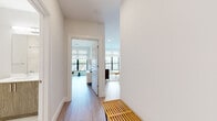 Located at 118 Park Ave in Rutherford, NJ, this single-floor residence showcases a clean, modern aesthetic throughout. Light wood-tone flooring runs continuously across the space, complementing the crisp white walls and creating a bright, cohesive atmosphere.

The kitchen is a standout feature, outfitted with sleek, dark high-gloss cabinetry, stainless steel appliances including a gas range, microwave, dishwasher, and a full-size refrigerator. A white waterfall-edge island with bar seating provides additional counter space and a casual dining option.

The living area is anchored by an expansive bank of black-framed windows that flood the room with natural light and offer views of the surrounding neighborhood. The open layout transitions seamlessly from the kitchen through to a welcoming hallway.

The bedroom is generously proportioned, featuring large windows, light-filled interiors, and direct access to a spacious walk-in closet equipped with dual hanging rods and built-in shelving — offering exceptional storage capacity.

A bathroom with marble-style finishes is visible in the floor plan, reinforcing the upscale character of the home. Throughout the residence, recessed lighting, roller shades, and carefully detailed millwork contribute to a polished, move-in-ready environment.