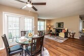 This single-floor residence offers a practical and comfortable layout across two bedrooms and two bathrooms. Warm-toned walls and hardwood flooring run throughout the main living areas, creating a cohesive and inviting atmosphere. The living room receives natural light through a large window and features a textured ceiling, providing a relaxed setting. Adjacent to the living room, the dining area is highlighted by a ceiling fan, additional windows with plantation shutters, and French doors that open to an outdoor area, enhancing the connection between interior and exterior spaces.

The kitchen is equipped with stainless steel appliances, including a range, microwave, and refrigerator, complemented by warm wood cabinetry and dark countertops. One of the bathrooms conveniently houses a stacked washer and dryer unit alongside a tub-shower combination.

Both bedrooms feature plush carpeting and windows that allow natural light. The primary bedroom includes access to a walk-in closet fitted with wire shelving, while the second bedroom also offers closet space. Overall, the residence presents a functional and well-organized floor plan suited for everyday living.