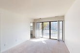 Located at Featherwood Court in Silver Spring, Maryland, this single-floor, 2-bedroom, 2-bathroom residence offers a practical and comfortable layout. The living room is bright and welcoming, featuring wall-to-wall carpeting and large sliding glass doors that open onto a private balcony, allowing abundant natural light and outdoor views to fill the space. The adjacent dining area flows naturally from the living room, creating an open, connected common area.

The kitchen is equipped with light wood cabinetry, dark countertops, wood-look flooring, and white appliances including a gas range and refrigerator, providing a functional space for everyday cooking. A closet within the kitchen area offers additional storage convenience.

The primary bedroom is generously sized, featuring soft carpeting and multiple closets, including a spacious walk-in closet outfitted with wire shelving and hanging rods. The second bedroom is also carpeted and includes its own closet. Altogether, the residence features five closets, ensuring ample storage throughout.

The two bathrooms are finished with wood-look flooring and light wood vanities with white countertops. One bathroom includes a tiled walk-in shower with glass doors. A connecting hallway ties all rooms together efficiently. The overall aesthetic is clean, neutral, and move-in ready.