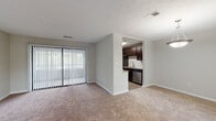Located at 6937 Roswell Rd in Sandy Springs, GA, this single-floor residence offers a well-organized layout designed for comfortable living. The open living area is generously sized, featuring neutral-toned carpet, soft gray walls, and a sliding glass door fitted with vertical blinds that fills the space with natural light while providing access to the outdoors. The living area flows conveniently toward a separate dining space, illuminated by a pendant light fixture and brightened by multiple windows.

The galley-style kitchen is a functional highlight, featuring rich dark-espresso cabinetry, granite countertops, a white subway tile backsplash, and wood-look flooring. Stainless steel appliances — including a refrigerator, range, microwave, and dishwasher — complete the well-equipped space. A window at the far end of the kitchen adds natural light.

The bedrooms are carpeted and spacious, each with natural light from windows, closet storage, and textured ceilings. One bedroom includes a ceiling fan for added comfort. The bathroom features dark-wood cabinetry, a large framed mirror, a bright vanity light fixture, and wood-look tile flooring, with a separate toilet and tub/shower area.