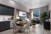 This single-floor residence showcases a thoughtfully designed interior that balances urban industrial elements with contemporary style. The entry hallway sets the tone immediately, featuring light wood-look flooring, louvered interior doors, and a bold abstract artwork that draws the eye toward the main living areas. Exposed concrete ceilings run throughout the unit, lending an industrial character that contrasts attractively with the warm, neutral-toned walls.

The living room is a standout space, anchored by large floor-to-ceiling windows that flood the room with natural light and frame sweeping city skyline views. A gray sofa and pair of rich emerald green accent chairs create a vibrant focal point, complemented by layered area rugs and large-scale artwork.

The kitchen features sleek, flat-front navy cabinetry paired with stainless steel appliances, a classic white subway tile backsplash, and a cozy dining area with a round wood table. The bedroom offers a tranquil retreat with expansive city views, a well-organized open closet system, and curated artwork above the upholstered headboard. The bathroom is clean and functional, finished with large-format tile flooring and a full tub-shower combination with white subway tile surround.