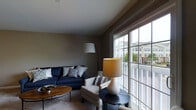 Located at 6400 Preserve Crossing Blvd N in Gahanna, Ohio, this three-story home offers a well-designed layout spread across multiple levels, providing ample space for comfortable living. The living area is a standout feature, characterized by warm neutral wall tones, plush carpeting, and an abundance of natural light streaming through large sliding glass doors and windows. These generous windows frame views of the surrounding community and a private balcony, seamlessly connecting the interior to the outdoors. The living room is thoughtfully laid out to accommodate both relaxed seating and functional entertaining, with room for a sofa, accent chairs, and decorative shelving. The open, airy feel of the space is enhanced by the soft, neutral color palette that runs throughout, creating a cohesive and inviting ambiance. With three floors of living space, this home offers versatility and room to grow, making it well-suited for a variety of lifestyles. The Preserve Crossing community in Gahanna provides a scenic backdrop, with mature trees and neighboring architecture visible from the interior windows, adding a sense of community and natural surroundings to everyday living.